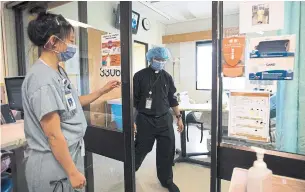  ?? JONATHAN HAYWARD THE CANADIAN PRESS ?? Rev. Victor Fernandes leaves a COVID-19 patient’s room in the intensive care unit at St. Paul’s hospital in Vancouver on Tuesday. B.C. has capacity to process about 4,000 tests a day.