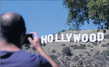  ?? DEAN MUSGROVE — STAFF PHOTOGRAPH­ER ?? A tourist gets close to the Hollywood sign on a pleasant afternoon Tuesday.