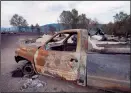  ?? CP PHOTO JONATHAN HAYWARD ?? Burnt out vehicles are pictured outside a burnt down residence along highway 3 in Rock Creek, B.C., Sunday. A wildfire swept through the area on Thursday claiming 29 homes and sending hundreds fleeing from the flames.