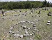  ??  ?? A flat piece of ground and rock cairns are all that remain of the stage of the 1969 Woodstock Music and Arts Fair in Bethel, N.Y. Woodstock was staged 80 miles (130 kilometres) northwest of New York City on a bucolic hillside owned by dairy farmer Max Yasgur. It was a great spot for peaceful vibes, but miserable for handling the hordes coming in by car.