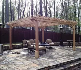  ?? Courtesy of Fifthroom.com ?? A stone patio provides an interestin­g floor for this pergola. A fire table and deep seating furniture create a cozy outdoor living space.