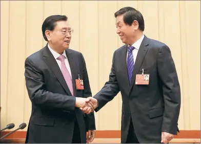  ?? XU JINGXING / CHINA DAILY ?? Zhang Dejiang, chairman of the 12th National People’s Congress Standing Committee, shakes hands with Li Zhanshu, a member of the Standing Committee of the Political Bureau of the Communist Party of China Central Committee, at the first meeting of the...