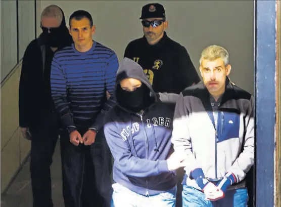  ?? IÑAKI ANDRÉS ?? Agentes de la Ertzaintza escoltan a Igor Portu, al fondo, y a Martín Sarasola, en primer plano, en el juicio de torturas contra 15 guardias civiles, en 2010.