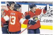  ?? TERRY RENNA/AP ?? Panthers center Jonathan Marchessau­lt, right, celebrates with Mark Pysyk (13) and Jakub Kindl after scoring.