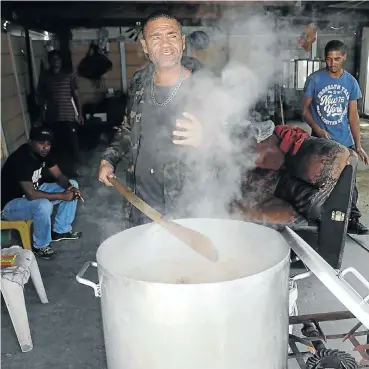  ?? Picture: Esa Alexander ?? Senior Mongrels gang member Leon ‘Poppie’ Meyer prepares the soup which he hands out to the community outside his home in the working-class suburb of Steenberg in Cape Town.