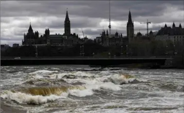  ?? JUSTIN TANG, THE CANADIAN PRESS ?? Parliament Hill and the Ottawa skyline are seen above the turbulent, high waters of the Ottawa River on Tuesday.