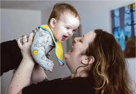  ?? Ellen M. Banner/Associated Press ?? Nicole Slemp lifts 7-month-old William in their Auburn, Wash., home. Slemp recently quit her job because she and her husband couldn’t find child care they could afford. Expensive, scarce child care is putting Puget Sound parents out of work.