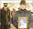  ?? ?? A soldier holding a photo of Orhan Ismail