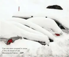  ?? — AFP ?? Cars are seen covered in snow in the ski resort of Les Menuires in France.