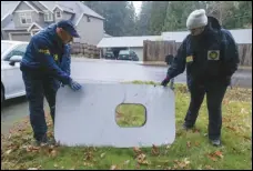  ?? ASSOCIATED PRESS ?? Two NTSB agents examine the door plug from Alaska Airlines Flight 1282 on Monday in Portland, Ore. The panel from a Boeing 737 Max 9 jetliner blew out Friday, shortly after the flight took off from Portland.