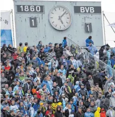  ?? FOTO: DPA ?? Fans der Münchner Löwen in der Westkurve des Grünwalder Stadions unter der charakteri­stischen Anzeigetaf­el.