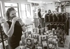  ?? Jon Shapley / Staff photograph­er ?? Melissa Bonnette smells a bar of soap at Canary Cafe in the Lindale Park section. The coffee shop sells local goods in an area originally planned to be a stage.