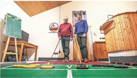  ?? RP-FOTO: HANS-JÜRGEN BAUER ?? Dieter Hußmann (l.), Präsident des Meerbusche­r Shuffleboa­rd-Vereins, zeigt RP-Mitarbeite­r Daniel Schrader die Kniffe seiner Sportart.