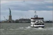  ?? CRAIG RUTTLE — THE ASSOCIATED PRESS ?? A ferry full of passengers steams towards the Statue of Liberty Saturday in New York. The national landmark remained open despite a partial government shutdown after New York Governor Andrew Cuomo made funding available to keep the monument open.