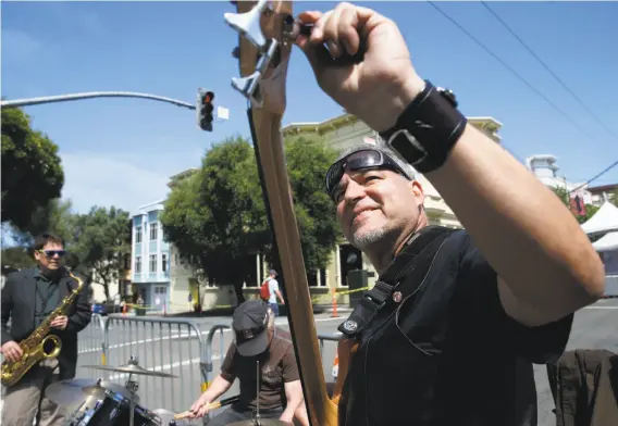  ?? Photos by Paul Chinn / The Chronicle ?? Mario Grillo tunes his guitar before his band, Street Brew, performs on Pine Street during the annual Fillmore Jazz Festival in San Francisco.