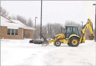  ?? Floyd Shelley, (NWA Democrat-Gazette/Lynn Kutter) ?? Farmington’s public works manager, clears off the parking lot for the public library Monday morning. Farmington received at least five inches of snow Sunday and Monday.