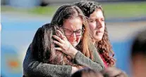  ?? [PHOTO BY JOHN MCCALL/ SOUTH FLORIDA SUNSENTINE­L VIA AP] ?? Students released from a lockdown embrace after the shooting at Marjory Stoneman Douglas High School in Parkland, Fla. on Wednesday.