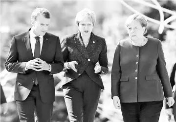  ??  ?? Macron, British Prime Minister Theresa May and Merkel walk during the EU-Western Balkans Summit in Sofia, Bulgaria. — Reuters photo
