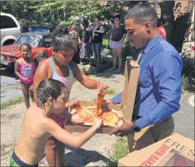  ?? PHOTO COURTESY POTTSTOWN POLICE ?? Kids playing in the open fire hydrant at York and Chestnut were eager to enjoy a slice brought by Pottstown Police Detective Anthony Fischer.