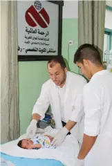  ??  ?? Medics treating a Palestinia­n infant at the Kuwaiti Hospital in Gaza.