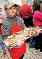  ??  ?? Volunteer Carter Morey carries pieces of pie Thursday.