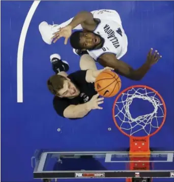  ?? MATT SLOCUM — THE ASSOCIATED PRESS ?? Xavier’s Sean O’Mara, bottom, tries to get a shot off Villanova’s Eric Paschall was having none of that. in the first half Wednesday night, but