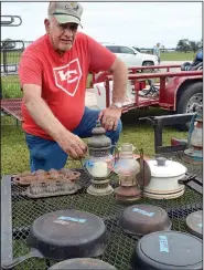  ?? (File Photo/NWA Democrat-Gazette) ?? Darl Patterson shows some of the lamps and cast iron skillets he is selling during the 2019 Pickin’ Time on 59 in Siloam Springs.