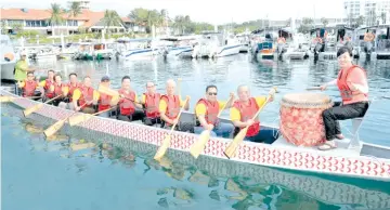  ??  ?? Goh (second right) and Wong (right) led the committee in steering the dragon boat during the launching for the training season of the Sabah FCAS Internatio­nal Dragon Boat Race.