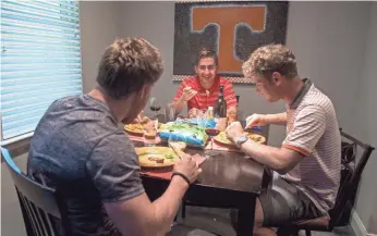  ?? BRIANNA PACIORKA, KNOXVILLE (TENN.) NEWS SENTINEL ?? Tennessee athletes, from left, Ryan Coetzee, Juan Carlos Serrano and Lorenzo Scalise dine together most nights, with Jack Smith, not shown. The roommates represent four countries.