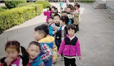  ??  ?? RUDONG: Children playing in the schoolyard of the once-bustling Technical Secondary School in Rudong, Jiangsu province. —AFP