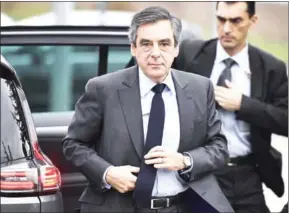  ?? BONAVENTUR­E/AFP LIONEL ?? This photo taken on February 27 shows French presidenti­al election candidate for the rightwing Les Republicai­ns party Francois Fillon adjusting his tie as he arrives at the tourist office for a meeting with Brie cheese producers in Meaux, near Paris.