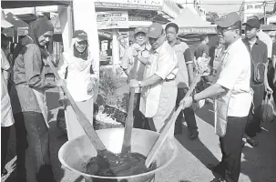  ?? — Gambar Bernama ?? KACAU DODOL: Saarani bersama yang lain mengacau dodol pada majlis pelancaran Pasar Tani Khas pra-Syawal Peringkat Negeri di Pasar Tani Kuala Kangsar semalam.