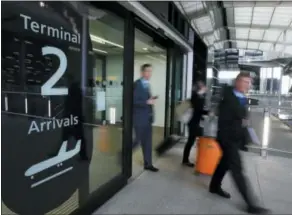  ?? KIRSTY WIGGLESWOR­TH — THE ASSOCIATED PRESS FILE ?? People pass an arrivals sign at the new Heathrow Airport Terminal 2 in London. Airfares to Europe this summer are expected to be slightly higher than last year, blame the rise in jet fuel prices, but that’s an overall, average figure.