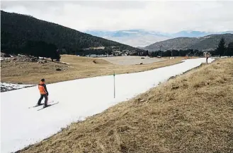  ?? ?? Un esquiador llisca per una pista de neu fabricada artificial­ment