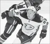  ?? Darryl Dyck Associated Press ?? THE DUCKS’ Ondrej Kase, foreground, is checked by Vancouver’s Ben Hutton during Thursday’s game.