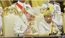  ?? — Bernama photo ?? Sultan Nazrin signs the instrument of office at Istana Negara.