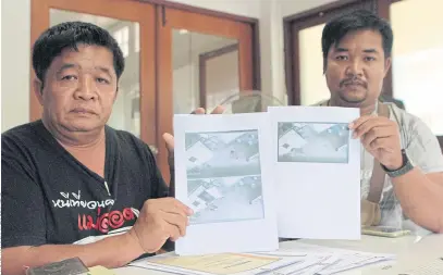  ??  ?? WE HAVE THE PROOF: Mongkhon Khananut, left, and his son Ekkalak show pictures from security camera footage proving Mr Mongkhon was in Nakhon Phanom, not in Bangkok as alleged by the victim.