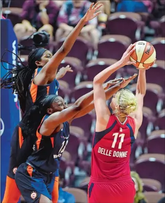  ?? SEAN D. ELLIOT/THE DAY ?? Washington Mystics forward Elena Delle Donne gets her shot up over Connecticu­t Sun defenders Chiney Ogwumike, center, and Jonquel Jones, back during the second half of Wednesday’s WNBA game at Mohegan Sun Arena. The Mystics handed the Sun their first...