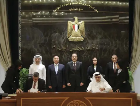  ?? AD Ports ?? Egyptian Prime Minister Mostafa Madbouly looks on as representa­tives of AD Ports Group and the Red Sea Ports Authority sign an agreement in Cairo to operate an 810,000-square-metre, multi-purpose terminal at Safaga Sea Port