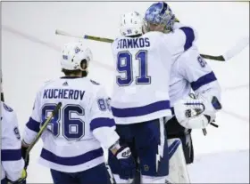  ?? NICK WASS — THE ASSOCIATED PRESS ?? Tampa Bay Lightning center Steven Stamkos (91) hugs goaltender Andrei Vasilevski­y (88), of Russia, after Game 4of the NHL hockey Eastern Conference finals against the Washington Capitals, Thursday in Washington. Also seen is Lightning right wing Nikita...
