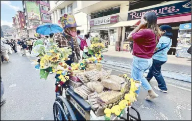  ?? ANDY ZAPATA ?? A man uses a wheelchair to peddle cookies along Session Road in Baguio City yesterday.