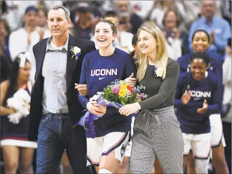  ?? Jessica Hill / Associated Press ?? UConn’s Katie Lou Samuelson is escorted onto the court by her father Jon and sister Karlie for senior day before a game against Houston on Saturday in Storrs.