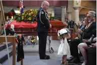  ??  ?? Top: Shane issued a “catastroph­ic fire danger” warning to the nation. Above: At the funeral for RFS volunteer Andrew O’Dwyer, Shane presented little Charlotte with her dad’s service medal.