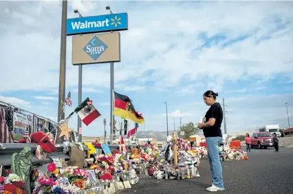  ?? Tamir Kalifa, © The New York Times Co. ?? Marcela Martínez, whose husband was seriously injured and whose father- in- law was killed in a mass shooting at a Walmart, visits a makeshift memorial at the site in El Paso, Texas, on Sept. 9, 2019.