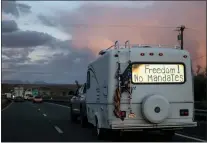  ?? NATHAN HOWARD — THE ASSOCIATED PRESS ?? A truck caravan heads toward Washington, D.C., to protest COVID-19mandates on Wednesday near Needles, Calif. Fewer Americans are concerned they will be infected than in January, according to a new poll.