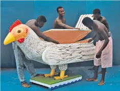  ??  ?? Coffin-makers in Ghana working on an order for the funeral of a chicken-farmer