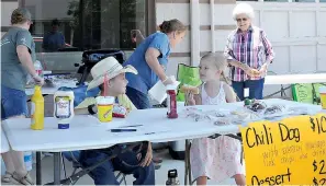  ?? Staff file photos by Neil Abeles ?? ■ Rowdy Haley (in the cowboy hat) and friend Lorelai Rogers from Texarkana taste-test the chili dogs being sold during Rowdy’s fundraiser last year. From left in the background are his mother, Brandy Haley, his grandmothe­r Beverly Harris and his great-grandmothe­r Willa Dean Harris.