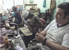  ?? ALAN GOMEZ, USA TODAY ?? Self-employed cobblers, repairmen and tailors use a shared workspace in central Havana.