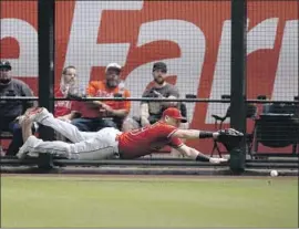  ?? Ross D. Franklin Associated Press ?? KOLE CALHOUN dives in vain for a double by Arizona’s David Peralta during the fifth inning in Phoenix. Peralta had three hits and drove in three runs.