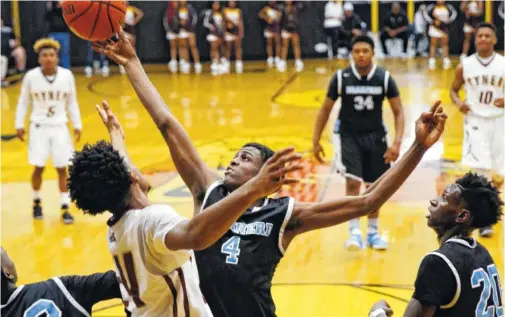  ?? STAFF PHOTOS BY DOUG STRICKLAND ?? Brainerd’s Vesta Melvin Jr. rebounds against Tyner’s Remeo Hubbard during the District 6-AA championsh­ip game at Hixson High School on Tuesday. The Rams came back from a seven-point halftime deficit to score 23 points, 13 of which were consecutiv­e, in...